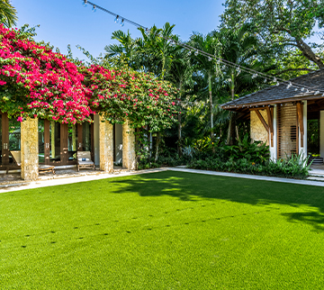 Backyard with an artificial grass lawn next to a garden