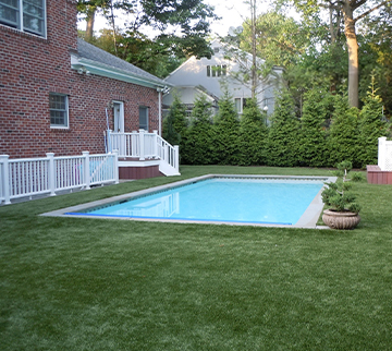 Large home with Pool surround featuring synthetic grass around it