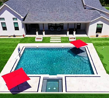 Texas home with Pool surround featuring synthetic grass around it