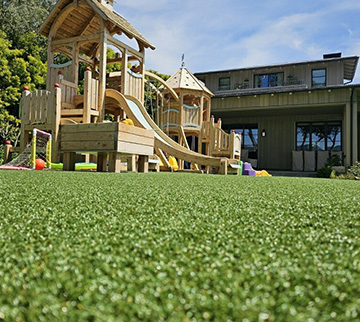 Backyard playground with synthetic grass installed