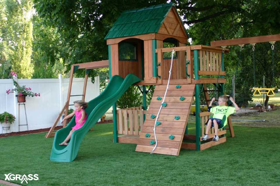 Girl sliding down from a backyard playground set