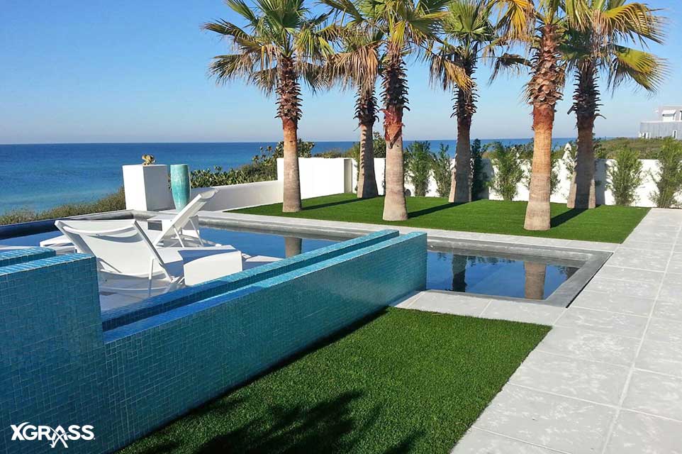 Backyard swimming pool in Miami with synthetic grass installed