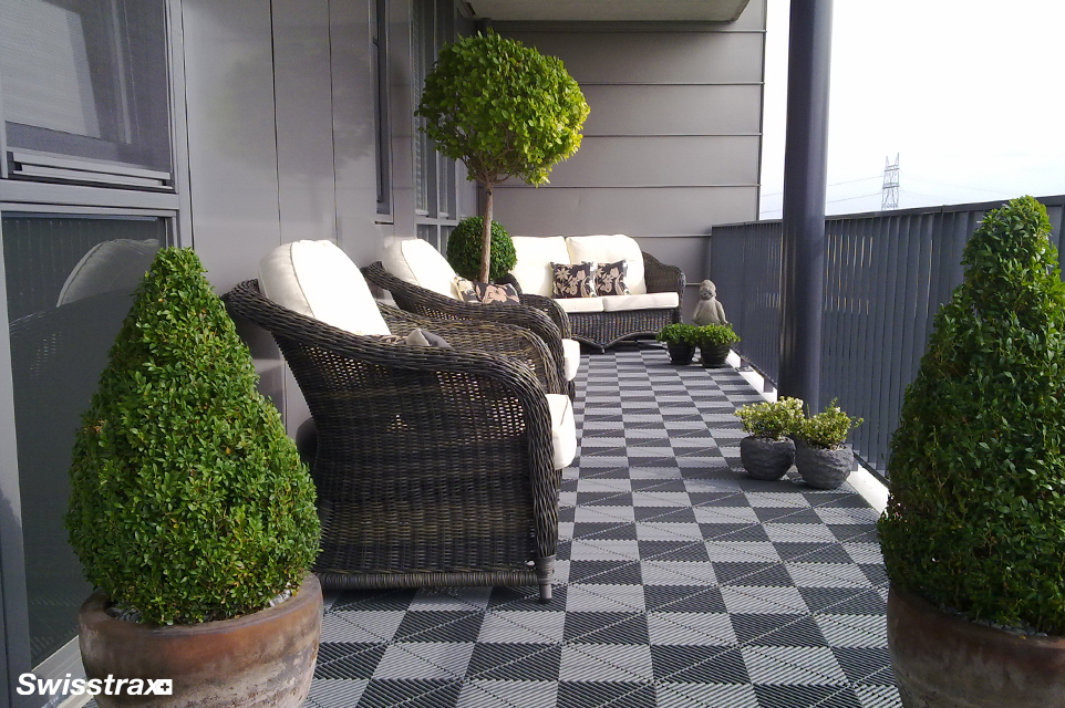 Gray modular floor tiles installed on the front porch of a home