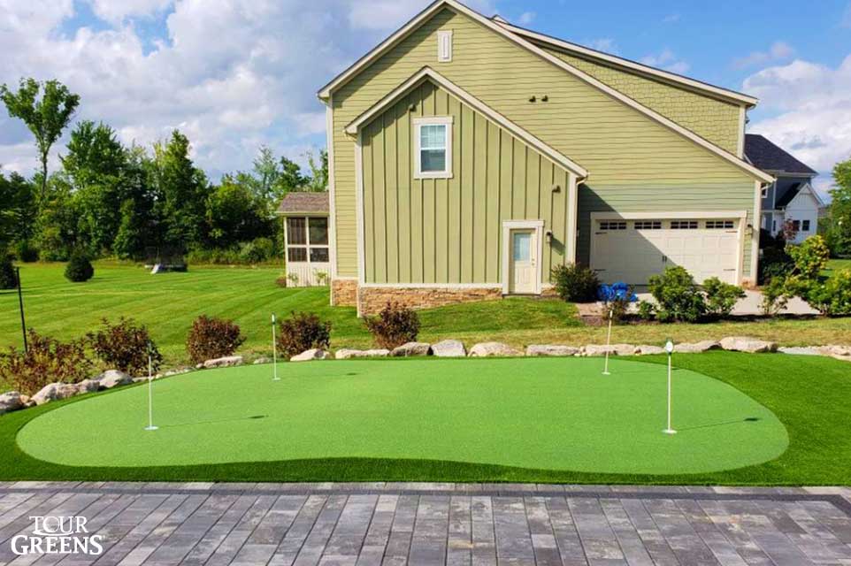 Small putting green next to the side of a house