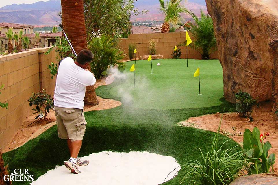 Small backyard putting green with sand bunker