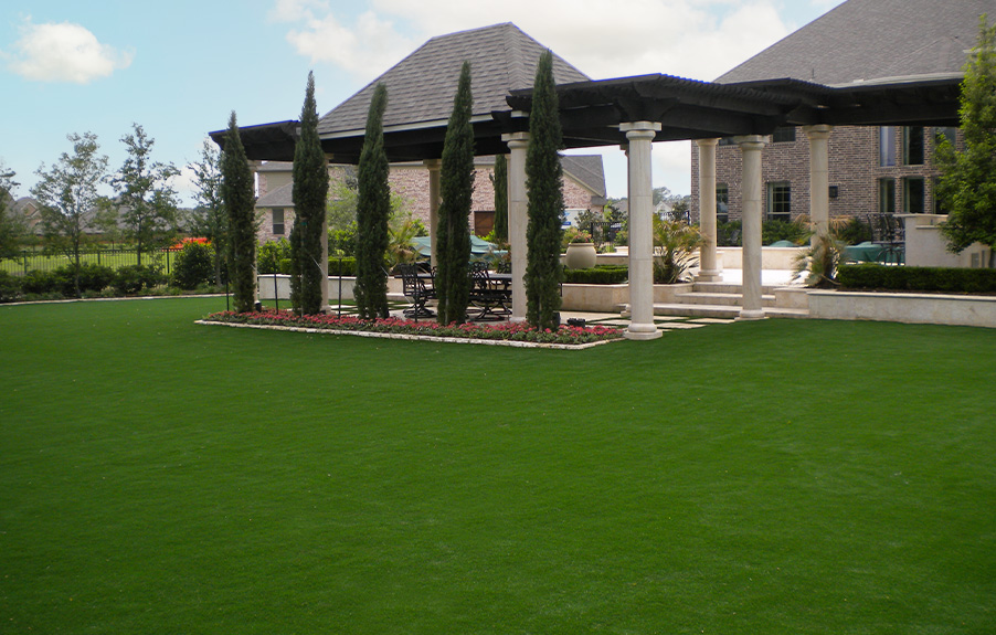Artificial grass lawn installed next to a large swimming pool
