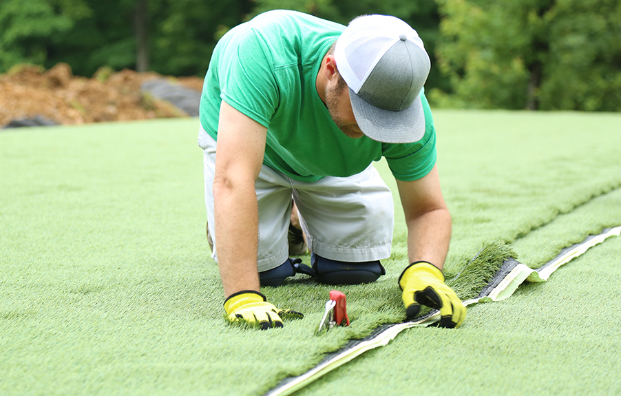 Lanmark Team Member Installing Artificial grass in orlando yard