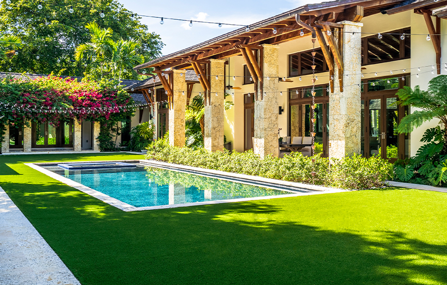 Backyard swimming pool with artificial grass installed around it