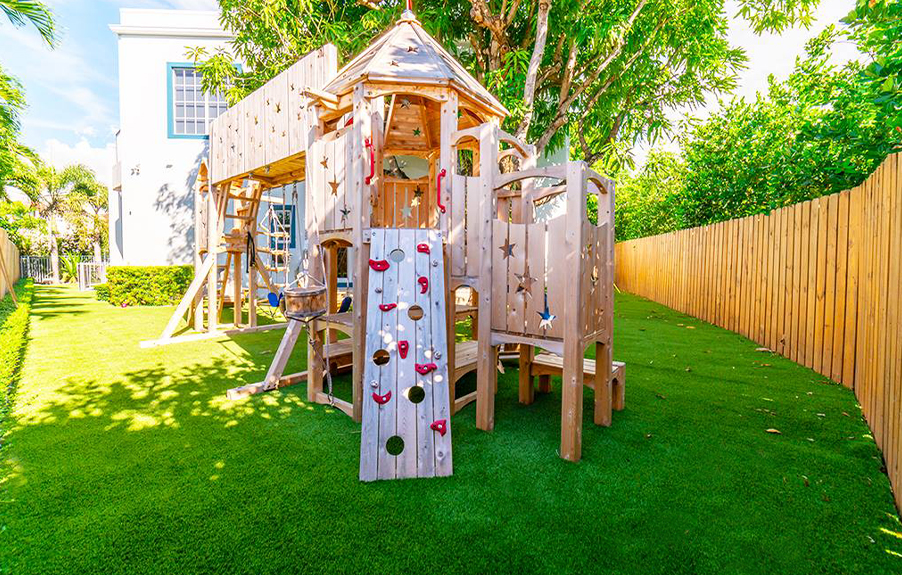 Backyard playground with artificial grass installed